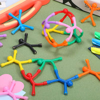 Colorful bendy magnetic men figures scattered on a play table