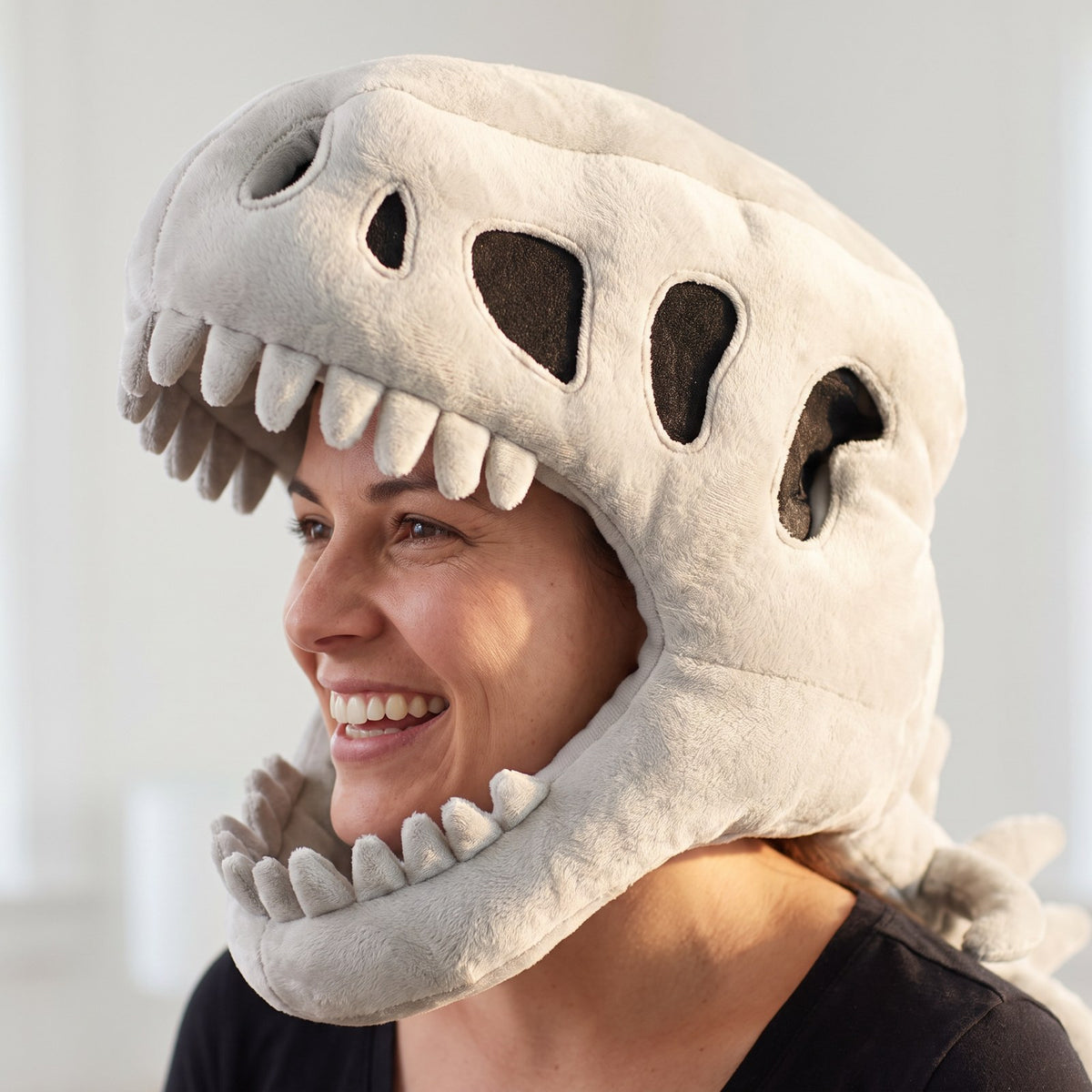 Adult wearing the plush T-rex skull hood, close-up